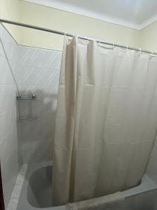 een badkamer met een douche met een wit douchegordijn bij Cardoso House VPA in Vila Praia de Âncora