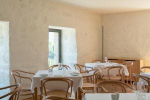 a room with white tables and chairs and a window at Quinta do Outeiro 1598 in Ponte da Barca