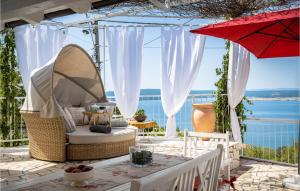 a patio with a chair and an umbrella and a table at Cozy Home In Crikvenica With Kitchen in Crikvenica