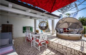 a patio with a table and chairs and an umbrella at Cozy Home In Crikvenica With Kitchen in Crikvenica