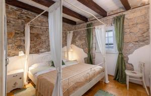 a bedroom with a bed and a stone wall at Cozy Home In Crikvenica With Kitchen in Crikvenica