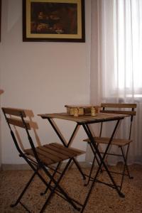 una mesa de madera y una silla con velas. en La casa di ViSi, en San Giacomo