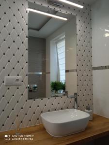 y baño con bañera blanca y espejo. en Apartament Storczyk, en Augustów