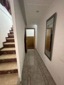 un corridoio con scale e specchio sul muro di Apartamentos Atlas Terrassa V a Terrassa