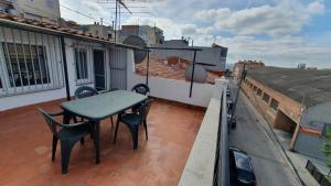 einen Balkon mit einem Tisch und Stühlen auf dem Dach in der Unterkunft Apartamentos Atlas Terrassa V in Terrassa