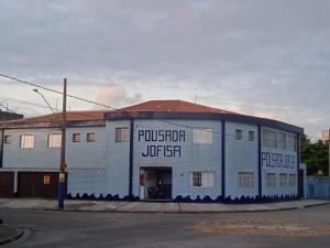 a white building on a street corner with aurger at Pousada Sereia Jofisa in Itanhaém