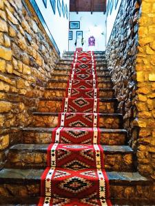 uma escada com uma fila de alcatifas vermelhas e brancas em Guva Mangalem Hotel Restaurant em Berat