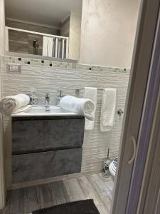 bagno con lavandino e servizi igienici con asciugamani di Giordana house a Catania