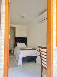 1 dormitorio con 1 cama y 1 silla en Quarto c/ Banheiro próximo a Praia da Barra da Tijuca, en Río de Janeiro