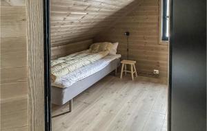 Bett in einem Zimmer mit einer Holzwand in der Unterkunft Lovely Home In Vikes With Kitchen in Vikeså