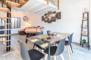 a dining room with a glass table and chairs at Appartement terrasse Duplex climatisé au cœur de Beziers in Béziers