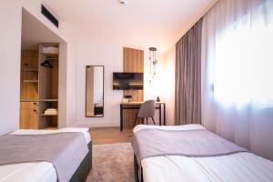 ComăneştiにあるPensiunea Casa Georgiaのベッド2台と机があるホテルの部屋