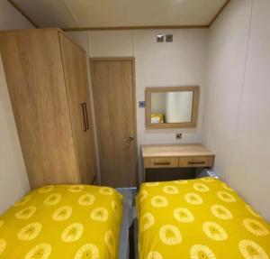 um pequeno quarto com 2 camas e um espelho em Luxe Lodge em Ulrome