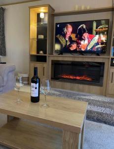uma garrafa de vinho e dois copos numa mesa na sala de estar em Luxe Lodge em Ulrome