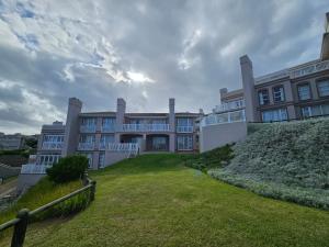 Un gran edificio con césped delante. en A Shot Of Luck, en Mossel Bay