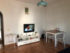 プエルト・デル・カルメンにあるLittle Gem Lanzaroteのリビングルーム(テーブル、壁掛けテレビ付)