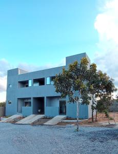 a blue building with a tree in front of it at Villa da Serra in Alto Paraíso de Goiás