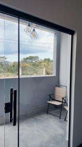 a room with a window and a chair and a fan at Villa da Serra in Alto Paraíso de Goiás