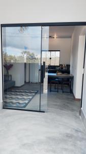 戈亞斯州上帕萊索的住宿－Villa da Serra，一间设有滑动玻璃门和桌子的房间
