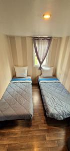 two beds sitting in a room with a window at Mobile home in Boofzheim