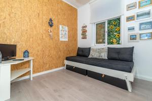 a room with a couch and a desk and a window at Beach House City in Figueira da Foz