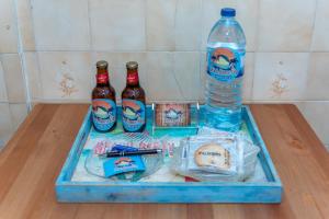 een dienblad met een fles water en twee flessen hiba bij Beach House City in Figueira da Foz