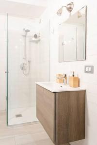a bathroom with a shower with a sink and a mirror at Luxury Loft a Milano - Design esclusivo e comfort moderno in Milan