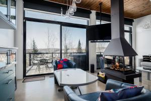 Saint-FaustinLoft Exécutif CherLieu de luxe avec vue sur golf et montagnes的带桌子和壁炉的客厅