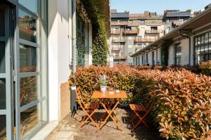 una mesa al lado de un edificio con plantas en Luxury Loft a Milano - Design esclusivo e comfort moderno en Milán