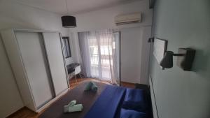 Pokój ze stołem z lustrem i niebieskim łóżkiem w obiekcie Koukaki near the Acropolis Stylish 2 bedroom w Atenach