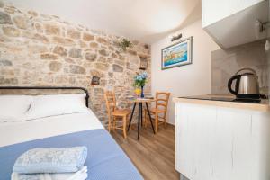 a bedroom with a bed and a table with chairs at Apartments Jerolim in Split
