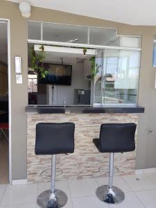 - deux chaises devant un bar avec une télévision dans l'établissement Queen's Residence VIP, à Tacna
