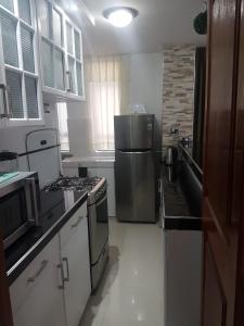 a kitchen with a stove and a refrigerator at Queen's Residence VIP in Tacna