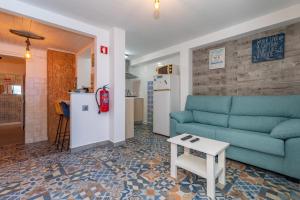 a living room with a blue couch and a table at Beach House City in Figueira da Foz