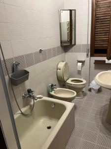 La salle de bains est pourvue d'une baignoire, de toilettes et d'un lavabo. dans l'établissement Bella Vista, à Baveno