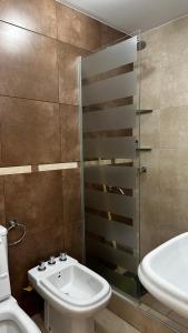 y baño con lavabo, aseo y ducha. en Apartments Biritos en Godoy Cruz