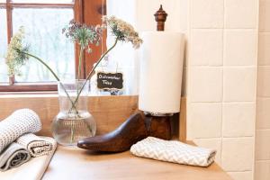 The Riverside Tailor's Retreat at Wray في Wray: طاولة مع أحذية ومزهرية ونافذة +51 صورة