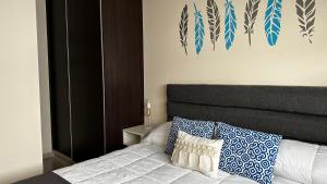 een slaapkamer met een bed met blauwe en witte kussens bij Apartments Biritos in Godoy Cruz
