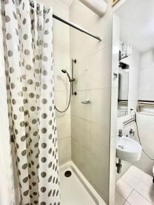 łazienka z zasłoną prysznicową i umywalką w obiekcie Bezagenta Rooms Centrum w Warszawie