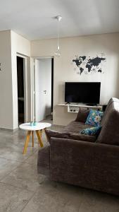 uma sala de estar com um sofá e uma televisão de ecrã plano em Apartments Biritos em Godoy Cruz