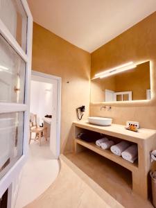 uma casa de banho com um lavatório e um espelho em Esmi Suites Santorini em Imerovigli