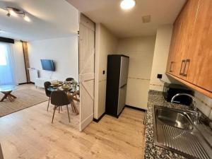 a kitchen and living room with a table and a refrigerator at El rincón de Martín en Huesca in Huesca