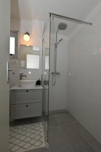 a white bathroom with a shower and a sink at Romantic Escape With Private Hot Tub Near Split in Žrnovnica +42 photos