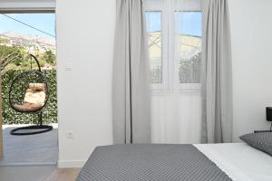 a bedroom with a bed and a chair and a window at Romantic Escape With Private Hot Tub Near Split in Žrnovnica