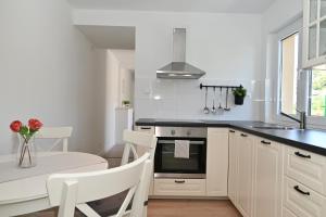 a kitchen with white cabinets and a black counter top at Romantic Escape With Private Hot Tub Near Split in Žrnovnica