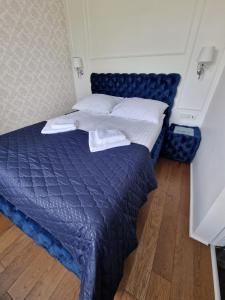 een slaapkamer met een blauw bed met witte kussens bij Apartament Helenka in Hajnówka