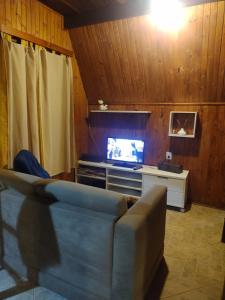 a living room with a couch and a television at Chalet confortável na cidade das estrelas in Santa Maria Madalena
