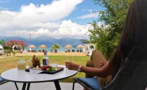 Seacret Apartments في سيليانيتيكا: امرأة تجلس على طاولة مع طبق من الطعام