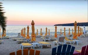 a beach with chairs and umbrellas and the ocean at City-Centre Studio 2 in Varna City