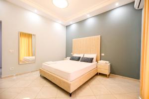 a bedroom with a large bed with a headboard at Villa Luisanna Free Parking in Vlorë